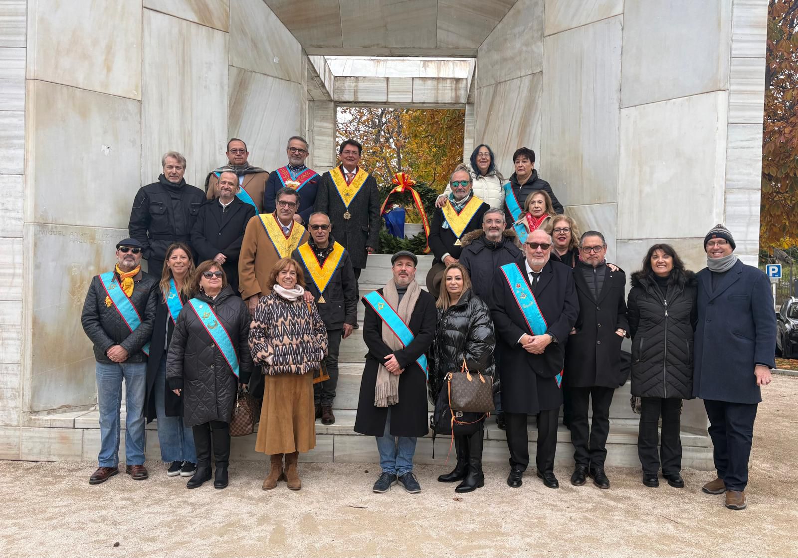 Grupo de miembros de la GLSE en un acto público y ofrenda floral ante el Monumento a la Constitución Española de 1978 en Madrid.