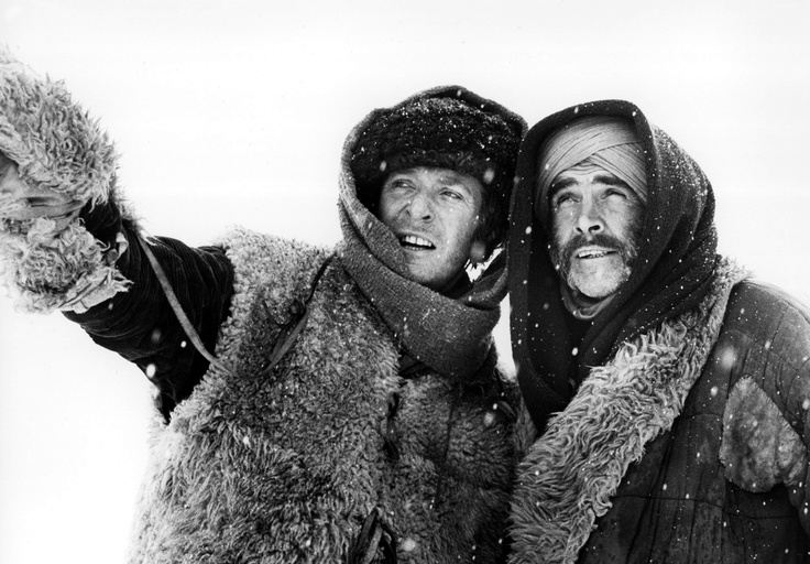 Aventura en la nieve — El hombre que pudo reinar Dos viajeros abrigados en la nieve señalan hacia el horizonte, imagen en blanco y negro.